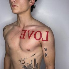 a shirtless man with tattoos on his chest and the word love written in red