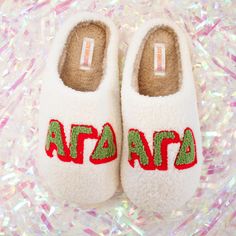 a pair of white slippers with letters on them