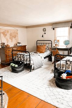 a bedroom with three beds and two dressers in the corner, one has a world map on the wall