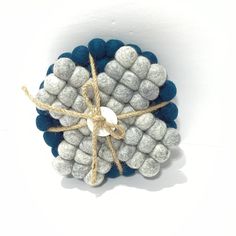 a blue and white ornament is tied up with twine on a white background