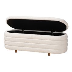 an upholstered white ottoman with wooden legs and black lining on the top, in front of a white background