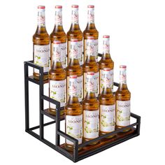 twelve bottles of syrup are stacked on a rack with metal holders for each individual bottle