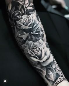 a black and white photo of a clock with roses on it's arm,