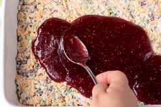 someone spooning jelly into a casserole dish