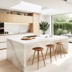 a kitchen with marble counter tops and stools next to an open window overlooking the backyard