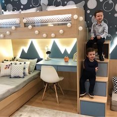 two young boys sitting on top of bunk beds in a child's playroom