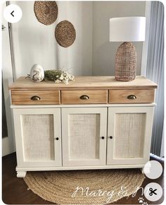 a white cabinet with wicker doors and two lamps on top of it next to a rug