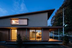 the house is lit up at night with its lights on and windows open to let in light