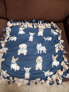 a blanket with dogs on it sitting on a couch