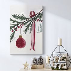 a christmas scene with ornaments and candles on a mantle next to a wall hanging ornament