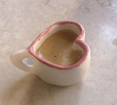 a white cup filled with liquid on top of a table