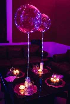 candles are lit on the tables in front of balloons and glass vases, along with wine glasses