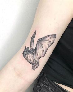 a small bat tattoo on the arm