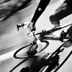 a person riding a bike down a street with their feet on the handlebars