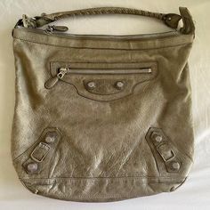 Grey Leather Balenciaga Motocross Giant 21 Day Hobo With Silver Tone Hardware, Single Rolled Shoulder Strap Featuring Whipstitch Trim, Exterior Zip Pocket At Front, Giant Raised Studded Embellishments With Buckle Adornments At Exterior, Black Woven Lining, Single Zip Pocket At Interior Wall And Zip Closure At Top. Includes Accompanying Mirror. Authentic Very Good Condition Bags Balenciaga, Interior Wall, Interior Walls, Grey Leather, Motocross, Balenciaga, Zip Pockets, Embellishments, Silver Tone