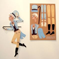 two wooden cutouts of people in blue outfits and hats, one is holding a pair of scissors