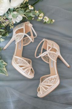 the bride's shoes and bouquet are sitting on top of her wedding dress sheet