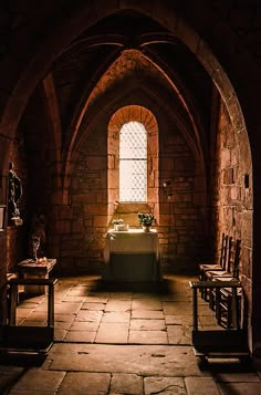 an old church with stone walls and arched doorways is lit by sunlight coming through the window