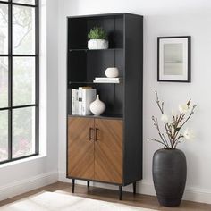 a black and brown bookcase next to a vase with flowers