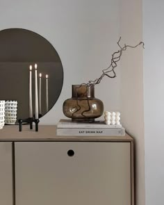 a dresser with candles and a mirror on it's sideboard in a room