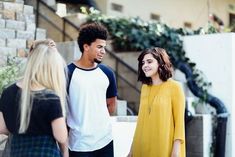 three people standing around talking to each other