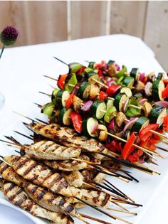 several skewers of food on a white plate