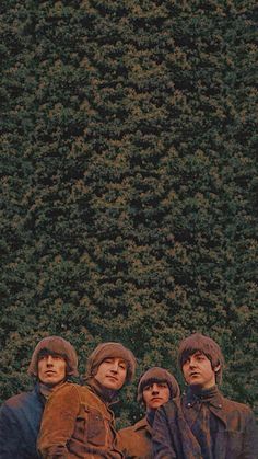 the beatles standing in front of a green wall