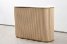 a beige and white counter sitting on top of a hard wood floor next to a wall