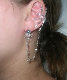 A beautiful spider web ear cuff with a connected spider earring! It hangs on the outside of whichever ear you want and can be bent to fit anyone's size of ear. If you want a pair pick quantity as two. The wire is silver plated with a two color toned glass bead for the spider! A made to order piece just in time for Halloween! You'll be able to customize this with different color beads and kinds of wire.  Note: If you want the spider to just dangle and not go into the earlobe. Just message me with your order and I will customize that for you! Thank you! Nickel-free Gothic Silver Body Jewelry, Nickel-free Silver Gothic Body Jewelry, Gothic Nickel-free Silver Body Jewelry, Fantasy Silver Body Jewelry For Party, Fantasy Style Silver Body Jewelry For Party, Witchy Metal Jewelry For Parties, Silver Punk Jewelry For Cosplay, Silver Mystical Jewelry For Party, Gothic Silver Jewelry For Cosplay