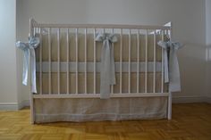 a baby crib with blue and white bows on it