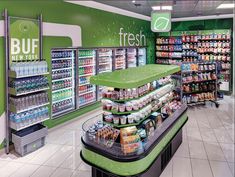 the interior of a grocery store filled with fresh foods and drink products, including drinks