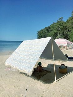 a white tent sitting on top of a sandy beach