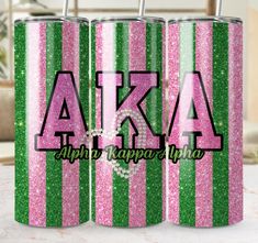 two pink and green glitter can coolers with the letters aka on them