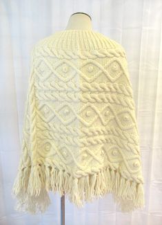 Cool vintage poncho of cream colored wool or wool blend. Pullover. One size fits all. Cute popcorn like balls throughout. Boat neck. Bust is 56 inches 25 inches long to bottom of the fringe. Notice how the outer edges hangs longer. No labels. More than likely hand made. Wonderful condition. Mannequin measurements are: 34 / 24-1/4 / 34-1/2 inches. Cute Popcorn, Fisherman Style, Knit Poncho, Knitted Poncho, The Fringe, Tartan Plaid, Cool Vintage, Sport Coat, Boat Neck