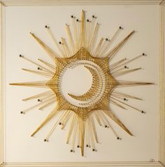 the sun and moon are made out of matchesticks in an intricate pattern on a white wall