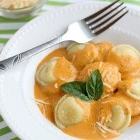 a white plate topped with dumplings covered in sauce