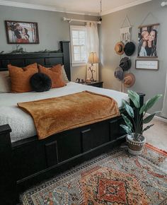 a bedroom with a bed, rugs and pictures on the wall above it's headboard