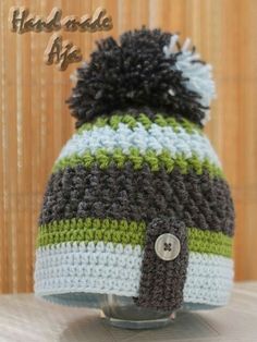 a crocheted hat with a button on the front and two different colored stripes