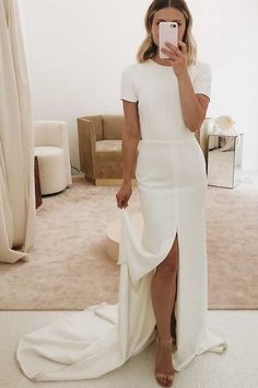 a woman in a white dress taking a selfie