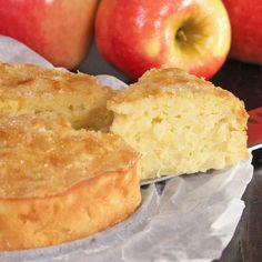 a close up of a piece of cake with apples in the background