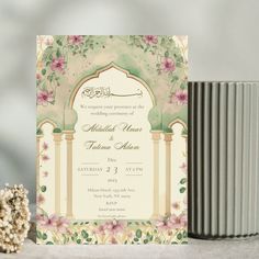 the wedding card is next to a vase with flowers on it and two candles in front