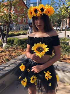 a woman wearing a sunflower headpiece and tutu skirt