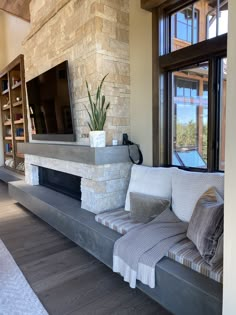 a living room filled with furniture and a flat screen tv mounted on a wall above a fireplace