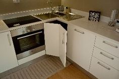 a small kitchen with white cabinets and stainless steel appliances