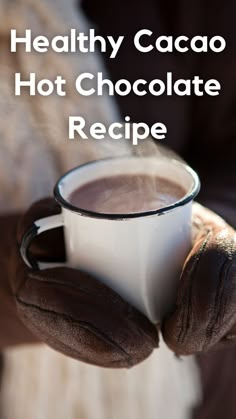 a person holding a cup of hot chocolate in their hands with the text healthy cacoa hot chocolate recipe