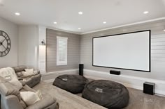 a living room with two bean bags on the floor and a projector screen in the corner