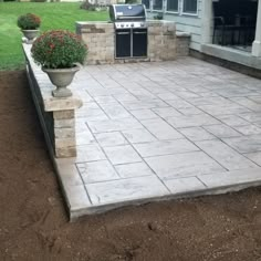 an outdoor patio with a grill and potted planter on the side of it