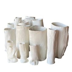 several white vases sitting next to each other