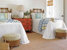 two beds in a room with white walls and wood trimming on the headboards