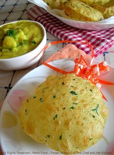 two plates filled with food on top of a table next to bowls of soup and bread